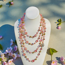Load image into Gallery viewer, Colorful beaded necklace on a mannequin bust with flowers around
