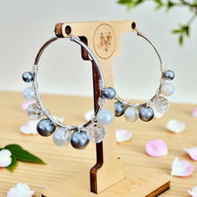 Load image into Gallery viewer, Pair of hoop earrings with beads on a wooden stand with a light background

